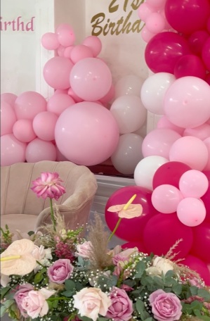 Pink balloon garland with floral arrangement